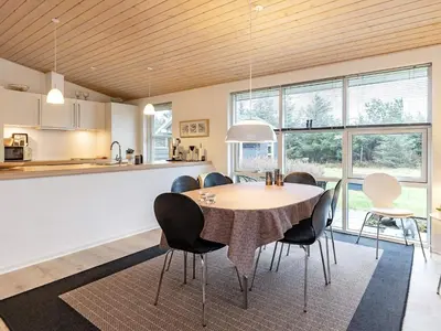 a kitchen and dining room with a table and chairs at Modern Retreat with Spa - By Traum Ferienwohnungen in Løkken