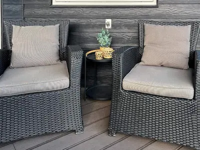 two wicker chairs sitting on a porch with a table at 8 person holiday home in Roslev-By Traum in Roslev