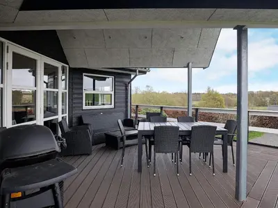 a patio with a table and chairs on a deck at 8 person holiday home in Roslev-By Traum in Roslev