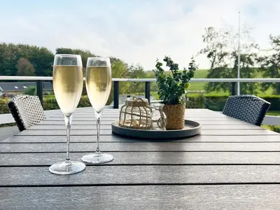 two glasses of white wine sitting on a wooden table at 8 person holiday home in Roslev-By Traum in Roslev