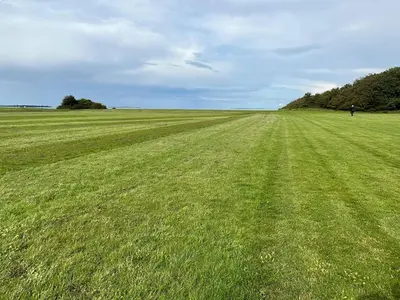 a large field of green grass with a person in the distance at 8 person holiday home in Roslev-By Traum in Roslev