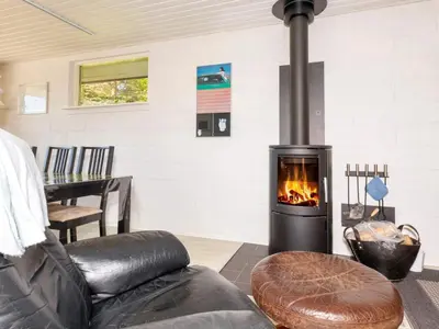 a fireplace in a living room with a couch and a chair at 5 person holiday home in Fur-By Traum in Fur