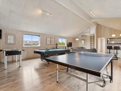 a room with a ping pong table and two tables at Luxury Retreat by Hostrup Beach - By Traum Ferienwohnungen in Spottrup