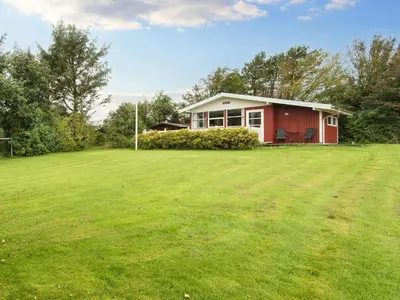 a red house in a field with a large yard at 8 person holiday home in Struer-By Traum in Struer