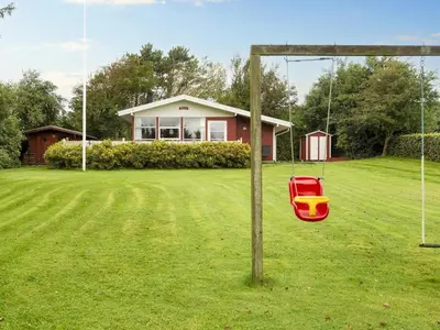 a swing in a yard in front of a house at 8 person holiday home in Struer-By Traum in Struer