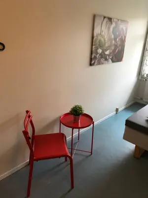 a red table and a red chair in a room at Danhostel Aalborg in Aalborg