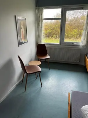 a room with two chairs and a table and a window at Danhostel Aalborg in Aalborg