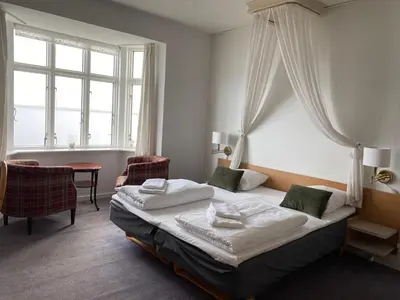 a hotel room with a bed and a window at Løgstør Badehotel - Hotel du Nord in Løgstør