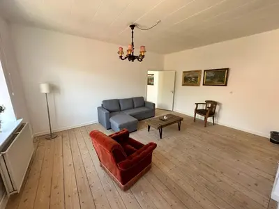 a living room with a couch and a table at Løgstør Badehotel - Hotel du Nord in Løgstør