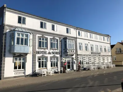 a large white building on the side of a street at Løgstør Badehotel - Hotel du Nord in Løgstør