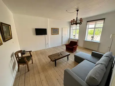 a living room with a couch and a table at Løgstør Badehotel - Hotel du Nord in Løgstør