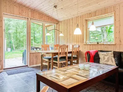 a living room with a table and a dining room at 6 person holiday home in Thyholm in Thyholm
