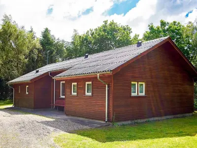 a small wooden cabin with a gambrel roof at 6 person holiday home in Thyholm in Thyholm