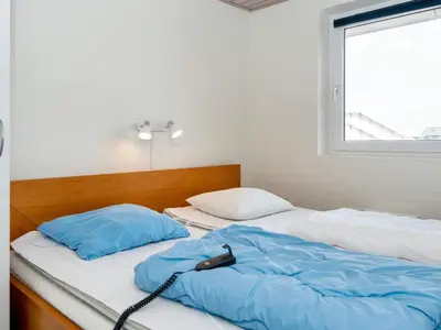 a bedroom with two beds with blue pillows and a window at 12 person holiday home in Harboøre-By Traum in Harboør