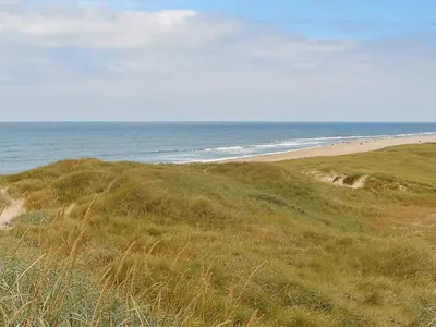 a view of a beach with people in the ocean at 12 person holiday home in Harboøre-By Traum in Harboør