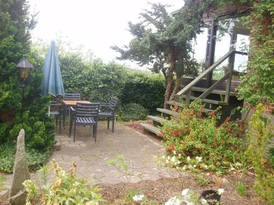 a patio with an umbrella and chairs and a table at Glyngøre Bed & Breakfast II in Glyngøre