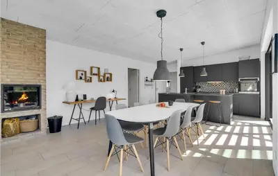 a kitchen and dining room with a white table and chairs at Three-Bedroom Holiday Home In Thisted in Thisted