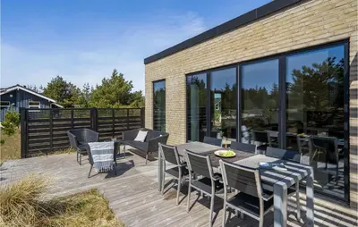 a wooden deck with a table and chairs at Three-Bedroom Holiday Home In Thisted in Thisted