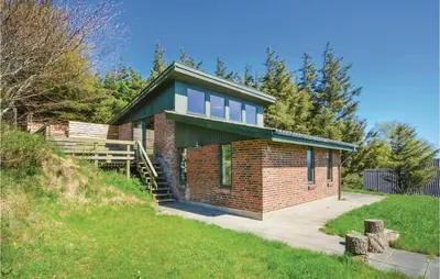 a brick house with a green roof on a hill at Three-Bedroom Holiday Home In Struer in Struer