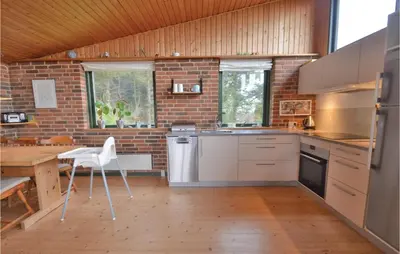 a kitchen with white appliances and a brick wall at Three-Bedroom Holiday Home In Struer in Struer