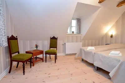 a bedroom with a bed and a table and chairs at Strømpehuset in Øster Assels