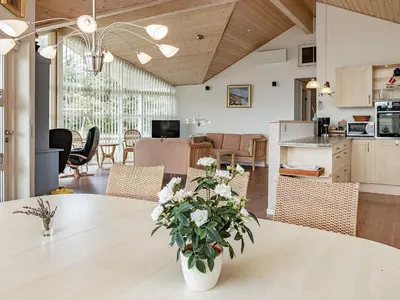 a kitchen and living room with a table with flowers on it at 8 person holiday home in Spøttrup in Spottrup