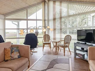 a living room with a tv and a table and chairs at 8 person holiday home in Spøttrup in Spottrup