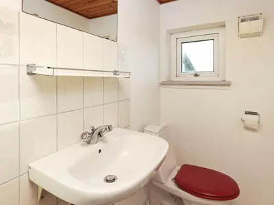 a bathroom with a sink and a toilet with a red seat at 10 person holiday home in Harboøre-By Traum in Harboør