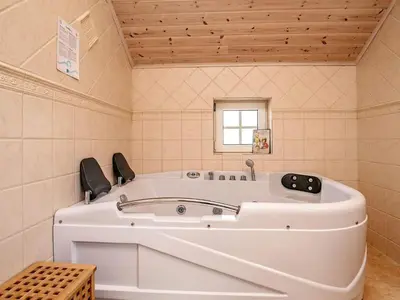 a large white tub in a bathroom with a window at Modern Retreat at Knud Strand - By Traum Ferienwohnungen in Spottrup