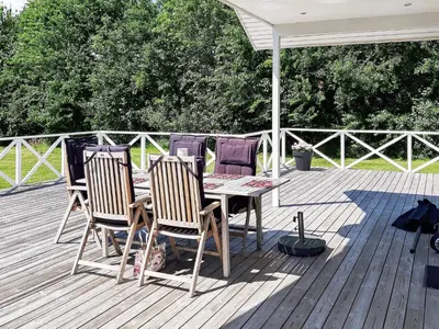 a table and chairs on a wooden deck at Modern Retreat at Knud Strand - By Traum Ferienwohnungen in Spottrup