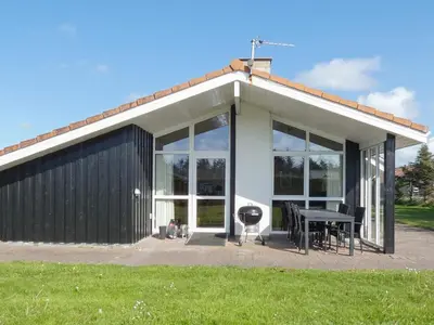 a house with glass doors and a table and a grill at 10 person holiday home in Løkken-By Traum in Løkken