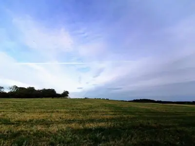 a field of grass with a blue sky and clouds at 10 person holiday home in Løkken-By Traum in Løkken