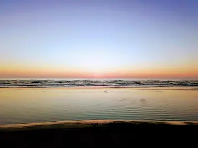 a sunset on the beach with the ocean at 10 person holiday home in Løkken-By Traum in Løkken