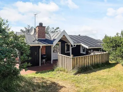 a black house with a fence in front of it at 4 person holiday home in Thisted-By Traum in Nørre Vorupør