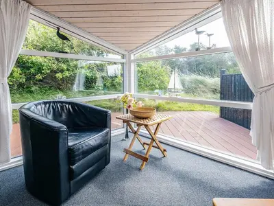 a living room with a black leather chair and a table at 4 person holiday home in Thisted-By Traum in Nørre Vorupør