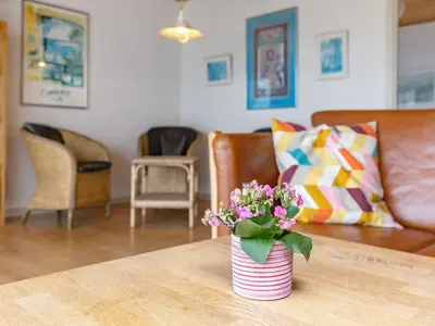 a vase of flowers on a table in a living room at Panoramic Seaside Escape - By Traum Ferienwohnungen in Frøstrup