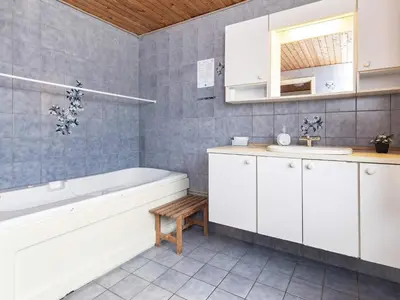 a bathroom with a white tub and a sink at Panoramic Seaside Escape - By Traum Ferienwohnungen in Frøstrup