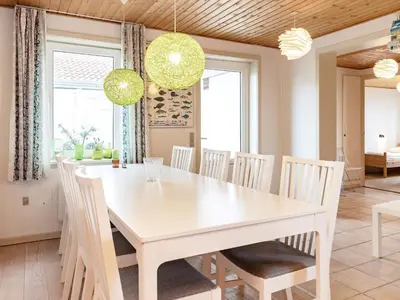 a dining room with a white table and chairs at Panoramic Seaside Escape - By Traum Ferienwohnungen in Frøstrup