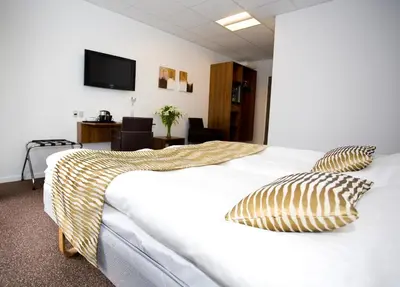 a hotel room with a bed with two pillows on it at Hotel Thinggaard in Hurup