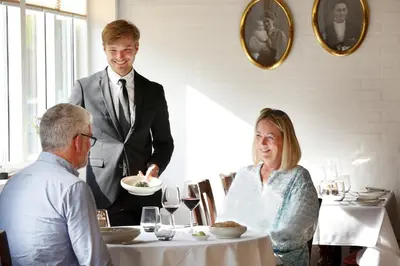 a man and a woman sitting at a table in a restaurant at Hotel Thinggaard in Hurup