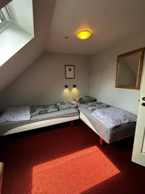 two twin beds in a room with a mirror at Oasen in Viborg