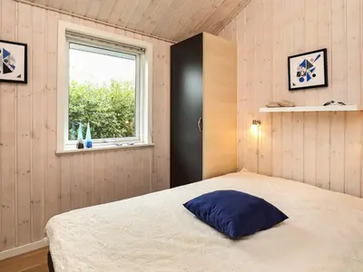a bedroom with a bed with a blue pillow on it at 8 person holiday home in Fjerritslev in Fjerritslev