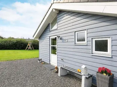 a blue house with a white door and a yard at 8 person holiday home in Fjerritslev in Fjerritslev