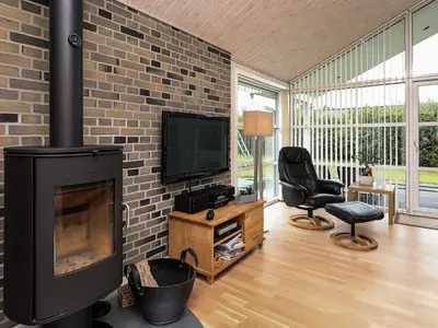 a living room with a fireplace and a television at 8 person holiday home in Fjerritslev in Fjerritslev