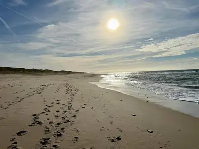 a beach with footprints in the sand and the ocean at 6 person holiday home in Thisted-By Traum in Torsted