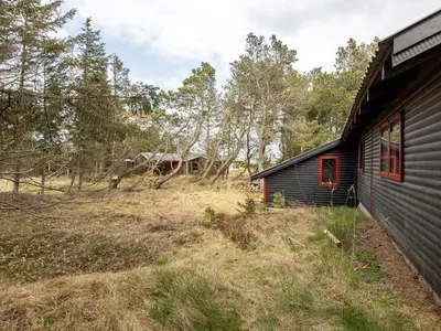 a house in a field next to a house at 6 person holiday home in Thisted-By Traum in Torsted