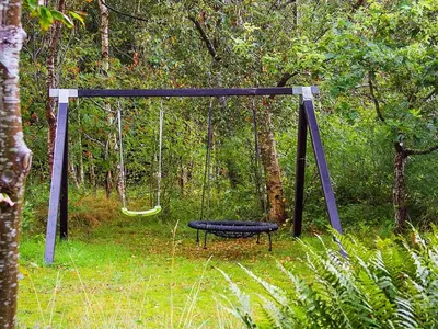 a swing in the middle of a forest at 8 person holiday home in Roslev-By Traum in Roslev
