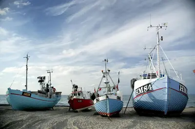 three boats sitting on the sand on the beach at Rønnes Hotel in Fjerritslev