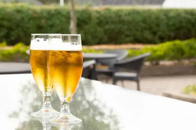 a glass of beer sitting on top of a table at Rønnes Hotel in Fjerritslev