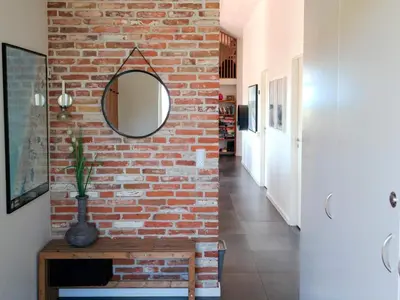 a brick wall in a hallway with a mirror at 8 person holiday home in Saltum-By Traum in Saltum